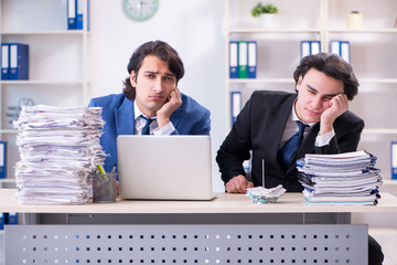 Two male colleagues unhappy with excessive work
