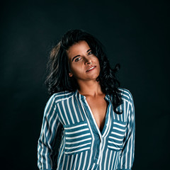Portrait of a young beautiful brunette with piercing, on a black background
