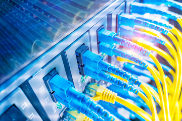 Fiber Optic cables connected to optic ports and UTP, Network cables connected to ethernet ports.