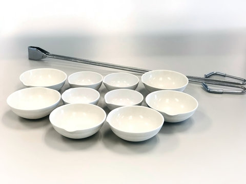 Evaporating Dish and Crucible tong prepare for analysis total solids in waste water sample, heat up at 103 degree celcius, selective focus and blur background. Has copy space.
