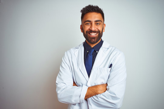 Young smiling doctor standing against white background