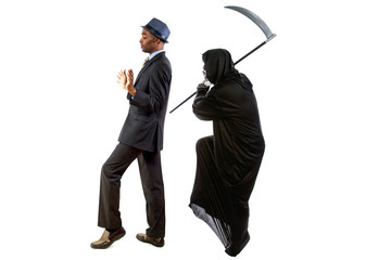 Man in a grim reaper halloween ghost costume having fun and scaring a grown businessman in a suit. ...