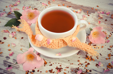 Vintage photo, Cup of tea with wild rose flower on old board