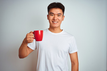 Asian chinese man holding red cup of coffee standing over isolated white background with a happy face standing and smiling with a confident smile showing teeth