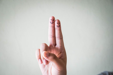 Happy finger smileys faces on hand with bokeh nature background, outdoor.