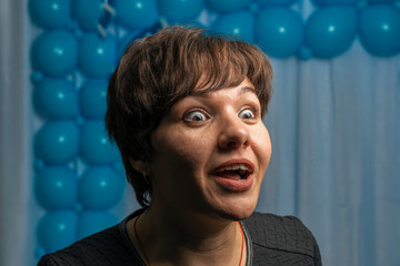 Young girl looks enthusiastically with open mouth and expression of surprise on her face.