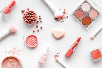 Makeup set with powder, rouge and brusheson white background top view pattern