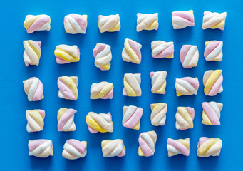 Marshmallows pattern on blue background top view flat lay