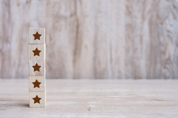 wooden blocks with the five star symbol. Customer reviews, feedback, rating, ranking and service concept.