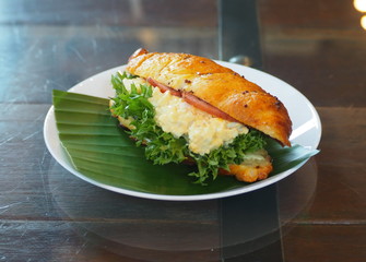 Croissant on a plate decorated with banana leaves