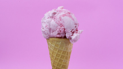 Strawberry ice cream scoop in waffle cone on pink background, Closeup Front view Food concept..