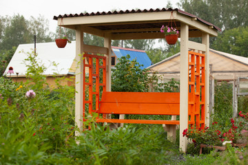 Wooden garden gazebo in the summer garden.