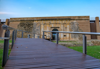 Wooden flooring on the bridge across the moat. Entrance to the old fortress. Historic building in Europe on a summer day on blue sky background. Preservation and popularization of historical monuments