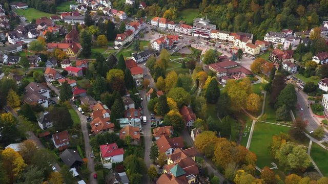 Aerial view of the city Bad Herrenalb in Germany on a sunny day in autumn, fall. Tilt up and zoom out from the town center.