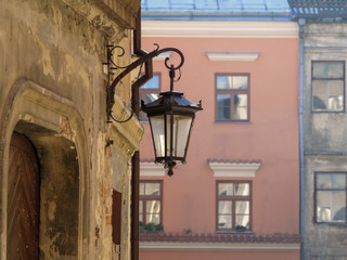 The vintage lantern hangs on the dilapidated wall of an old building on a city street in Lublin (Poland). Beautiful vintage picture of suburb or countryside with copy space © ioanna_alexa