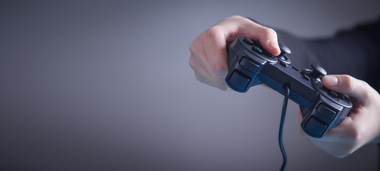 Hands using game controller. Playing video games