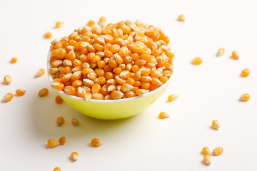 Dried corn seeds in bowl on white background 