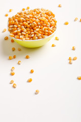 Dried corn seeds in bowl on white background 