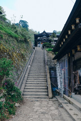 Long stone stairs to Japanese shrine (translation: japanese sign is Takaya Shrine, name of this shrine. Letters on the poles mean votive.)
