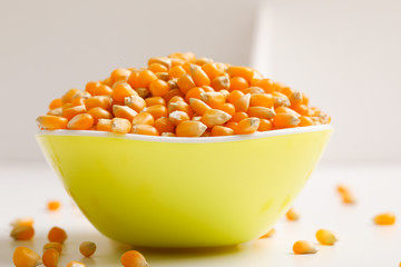 Dried corn seeds in bowl on white background 