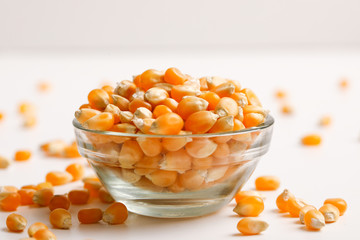 Dried corn seeds in bowl on white background 