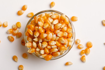 Dried corn seeds in bowl on white background 