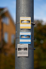 three metal signs with numbers and letters mounted on a lamp post, what are they good for