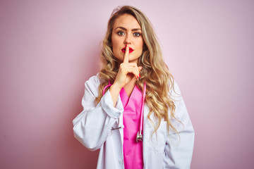 Young beautiful doctor woman using stethoscope over pink isolated background asking to be quiet with finger on lips. Silence and secret concept.