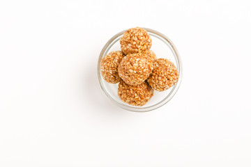 Indian sweet Sesame seeds ball or called in Hindi til ke laddu in glass bowl on white background 