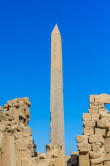 Granite obelisk against blue sky in a Karnak temple. Luxor, Egypt.