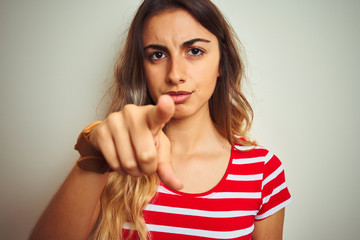 Young beautiful woman wearing red stripes t-shirt over white isolated background pointing with finger to the camera and to you, hand sign, positive and confident gesture from the front