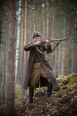 Obraz premium A soldier of World War II is holding the rifle in his hands and aiming