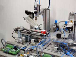 Industry 4.0 concept. Smart factory prototype, production line equipped with sensors, camera and pneumatic equipments. Selective Focus.