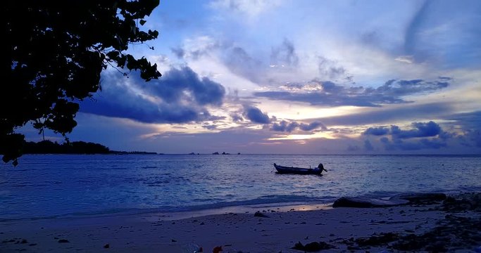 Shining sunset under dark clouds hanging over exotic bay, fishing boats anchored in Philippines
