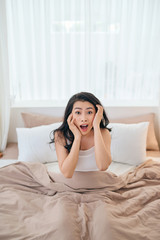 Asian girl shocked as she wakes up late.