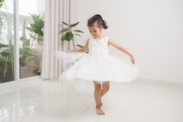 Happy cute preschooler girl dancing in living room