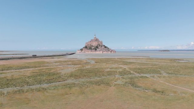 advancing aerial drone view of mont saint michel, France 2018-09-01 The island remained unconquered during the Hundred Years' War; a small garrison fended off a full attack by the English in 1433