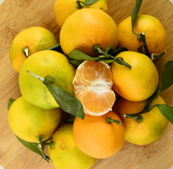 Tasty tangerines lie on a wooden surface. Yellow citrus fruits. Top view, side view. Sliced ​​tangerines.