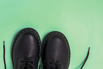 Classic leather boots isolated on pastel green background