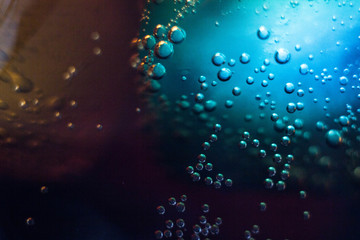 Air bubbles on a piece of ice in a liquid soda