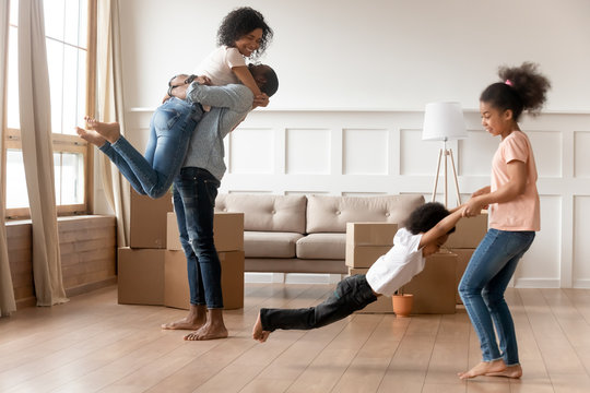 Excited black family with kids have fun on moving day