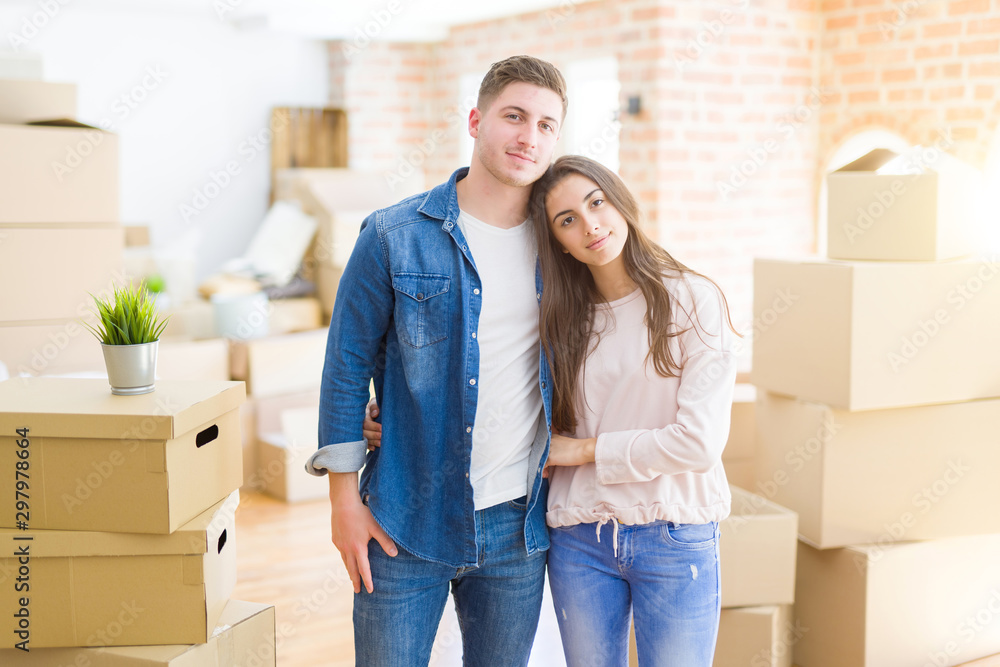 Canvas Prints Beautiful young couple moving to a new house with serious expression on face. Simple and natural looking at the camera.