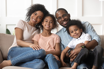 Portrait of black family with kids relax on couch - Powered by Adobe