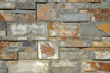 Wild yellow decorative stone background. Artificial ocher decorative bricks wall. Construction made...