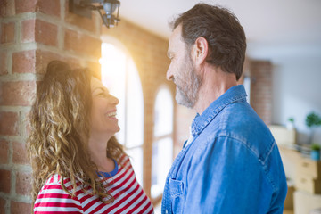 Middle age senior couple moving to a new house, smiling happy in love with apartmant