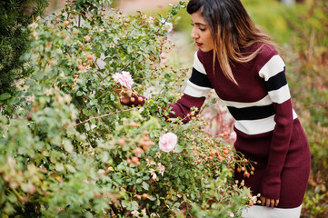 Portrait of young beautiful indian or south asian teenage girl in dress at flowers garden.