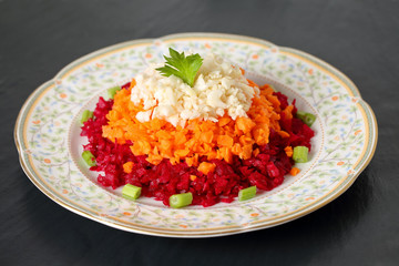Healthy and delicious vegetable salad on layers with chopped beet, carrot and celery