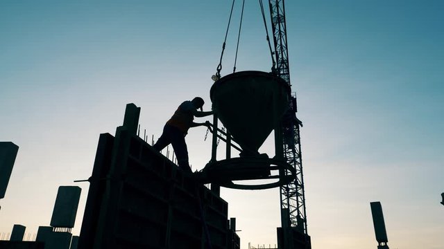 Male worker is operating a barrel with concrete on the roof