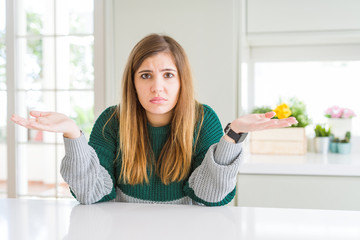 Young beautiful plus size woman wearing casual striped sweater clueless and confused with open arms, no idea concept.