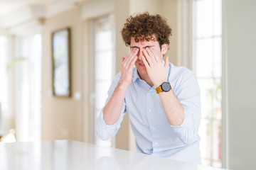 Young business man with curly read head rubbing eyes for fatigue and headache, sleepy and tired expression. Vision problem